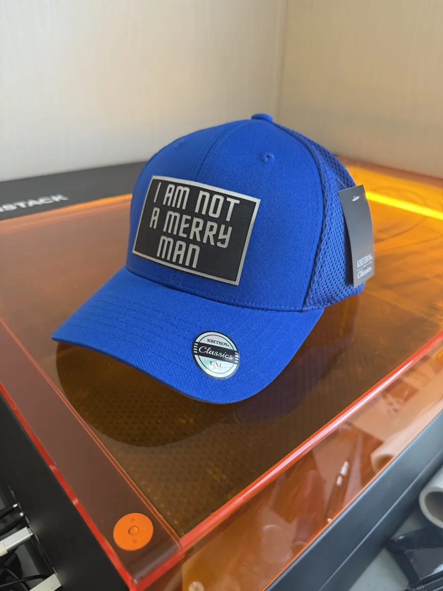 Blue cap with a black engraved custom message patch