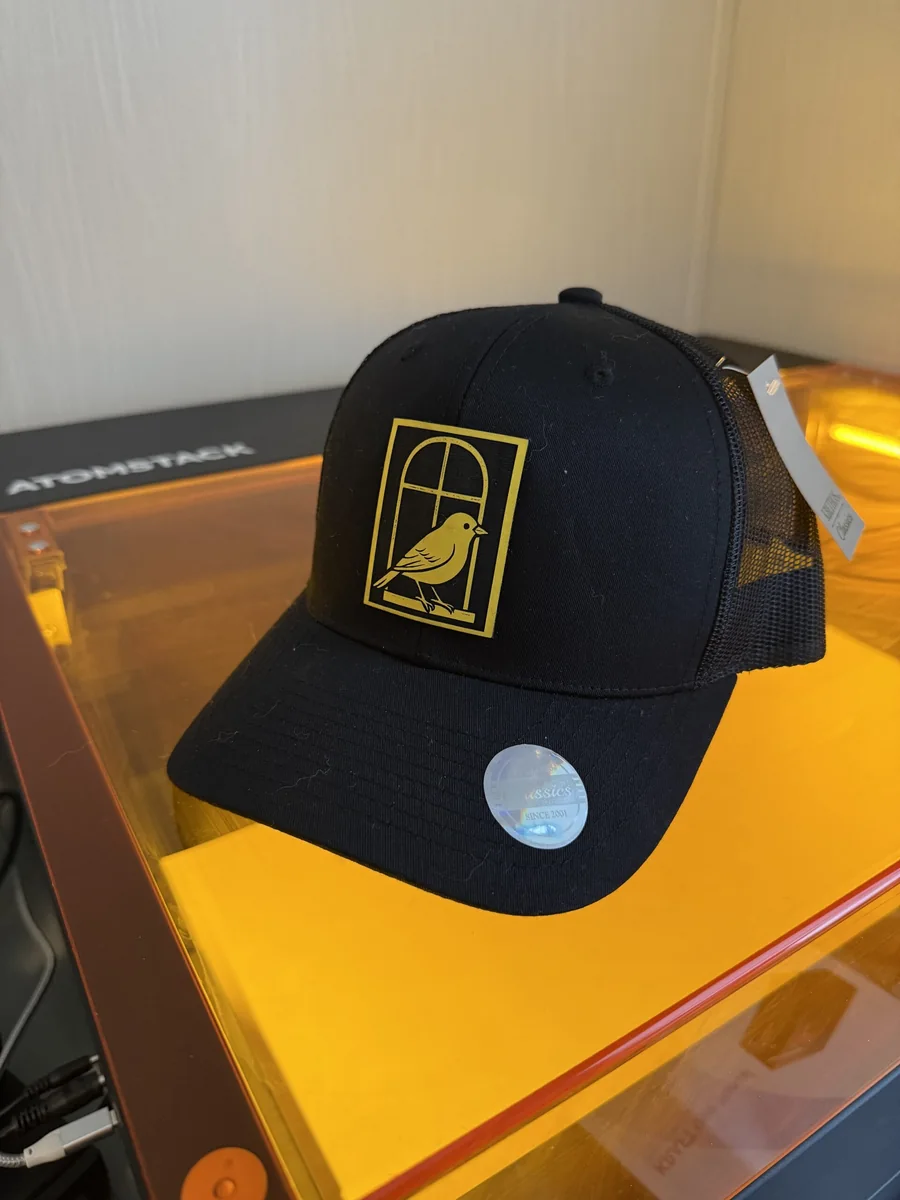 Black cap with a yellow bird patch referencing a Marine Corps running cadence